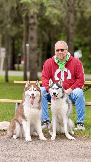 Jayson kneeling between Echo and Dee OhGee in front of the picnic tables